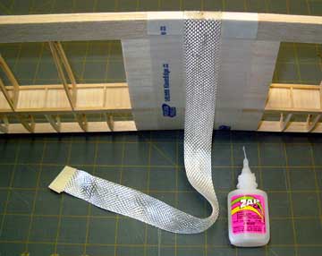 Tack one end of the fiberglass tape to the wing trailing edge using thin CA.