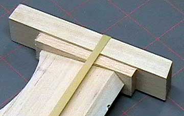 A large rubber band and a piece of hardwood makes an effective clamp.