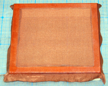 Silk is stretched over a frame to apply the silk to small, flat parts.