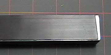 Magnetic strip attached to an aluminum extrusion.