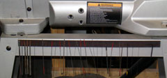 Scroll Saw Blades attached to a magnetic strip on the side of the saw stand.