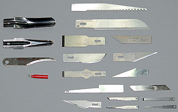 Various razor and scalpel blades with typical handles.